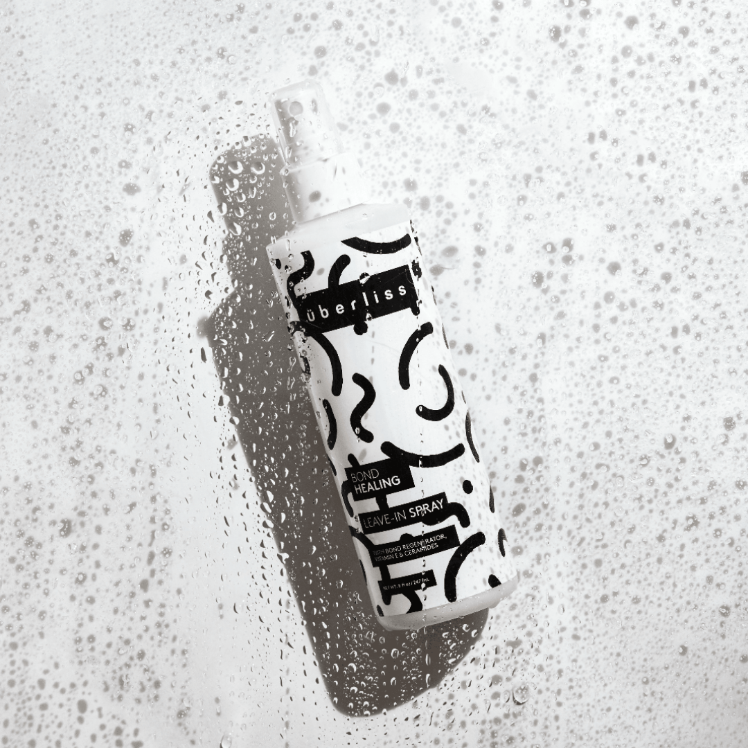 Bond healing spray bottle with black and white design on a textured gray background